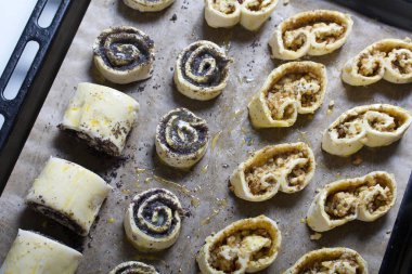 Haşhaş ve cevizle doldurulmuş bukleler. Yumurta sarısı ile kaplanmış. Fırın kağıdına uzan..