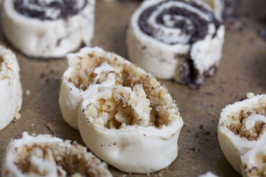 Fırın tepsisinde haşhaş ve cevizle doldurulmuş bukleler var. Pişirmek için..