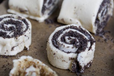 Fırın tepsisinde haşhaş ve cevizle doldurulmuş bukleler var. Pişirmek için..