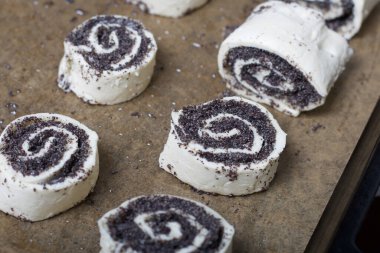 Fırın tepsisinde haşhaş ve cevizle doldurulmuş bukleler var. Pişirmek için..