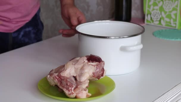 Человек наливает воду в кастрюлю и кладет туда замороженное куриное мясо. За приготовление соррельного супа. — стоковое видео