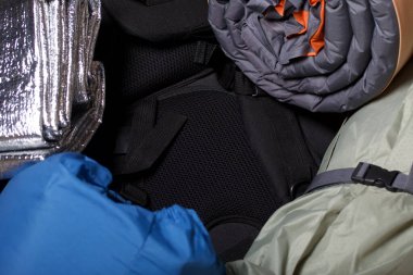 Turist ekipmanları. Kendini şişiren halılar, çadır ve spor ayakkabılar..