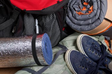 Turist ekipmanları. Kendini şişiren halılar, çadır ve spor ayakkabılar..