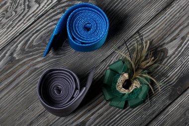 Farklı boylarda ve renkte iki erkek kravatı. Kadın broşu. Baba, anne ve oğul için. Aşk ve Birliktelik Nesneleri. Boyalı tahtalarda.