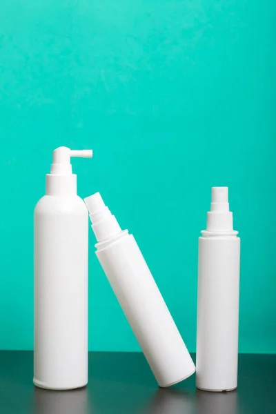 Sprayers with antiseptic, white. For surface treatment against viruses. Against a mint background.