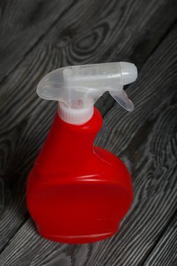Kırmızı plastik şişe ve sprey. Temizlik spreyi. Çam ağaçlarında.