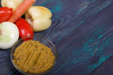 Yeni hazırlanmış kabak havyarı bir kabın içinde. Sebze ve yemek malzemelerinin yanında..