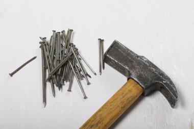 Eski bir çekiç ve bir avuç çivi. Beyaz arkaplanda.