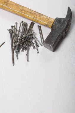 Eski bir çekiç ve bir avuç çivi. Beyaz arkaplanda.