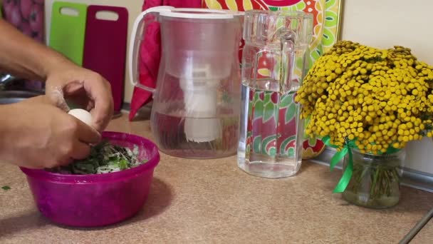 Preparation of cutlets from beet tops. A man mixes beet tops, flour and a chicken egg in a container. Regional food. — Stock Video