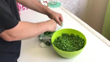 Adam vakum torbasını ezilmiş maydanozla dolduruyor ve içindeki havayı sıkıyor. Donmak için yeşiller. Sağdan çekiliyor..