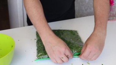Bir adam vakum torbasını maydanozla donmak için kapatır..