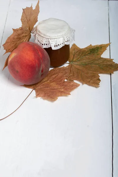 Jam Glass Jar Nearby Dried Maple Leaves Ripe Peach — Stock Photo, Image
