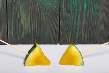 Çubuklardaki sarı karpuz parçaları..