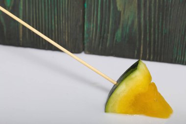 Çubuklardaki sarı karpuz parçaları..