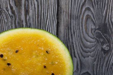 Boyalı çam ağaçlarının arka planında sarı karpuzu kes.