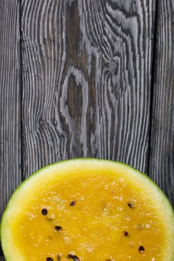 Boyalı çam ağaçlarının arka planında sarı karpuzu kes.