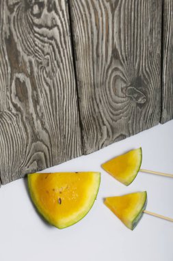 Çubuklardaki sarı karpuz parçaları..