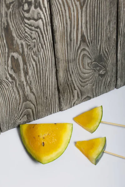 Çubuklardaki sarı karpuz parçaları..