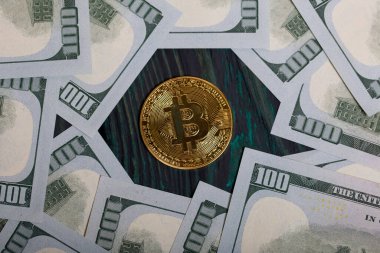 Dolar banknotları arasında altın bitcoin.