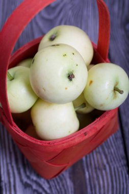 Kırmızı hasır sepetteki elmalar. Meyve hasadı.