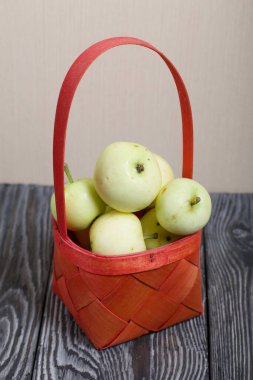 Kırmızı hasır sepetteki elmalar. Meyve hasadı.