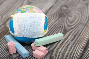 Tıbbi maskeli bir dünya. Yakınlarda boya kalemleri var. Salgın sırasında akademik yıl.