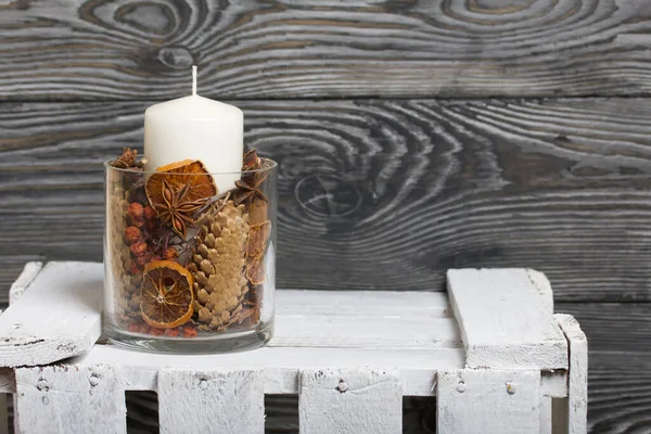 玻璃烛台上的蜡烛 烛台上满是干果 香料和干果 木箱上的立柱 — 图库照片