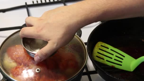 A man prepares bell peppers stuffed with minced meat and rice. Covered with saut��ed carrots with ketchup. — Stock Video