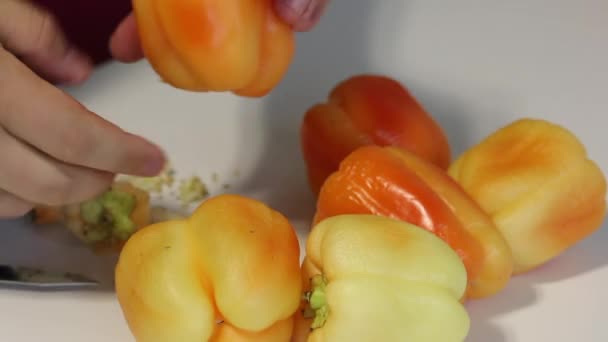 Ein Mann schält eine Paprika. Zum Füllen mit Hackfleisch und Reis. — Stockvideo