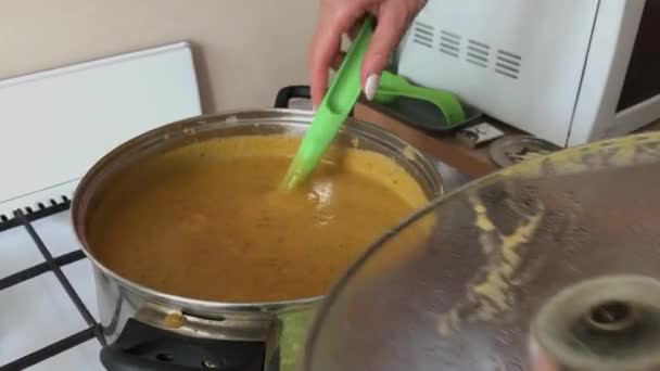 煮南瓜鱼子酱。一个女人用煤气炉在平底锅里搅拌南瓜鱼子酱. — 图库视频影像