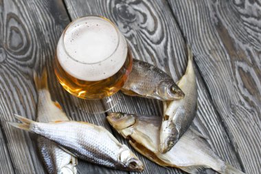 Bir bardak bira. Kurumuş nehir balığı yakınlarda yatıyor..