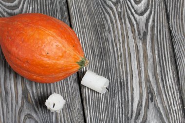 Turuncu balkabağı ve mum koçanları. Çam ağacından yapılmış tahtalarda siyah beyaz boyanmış..
