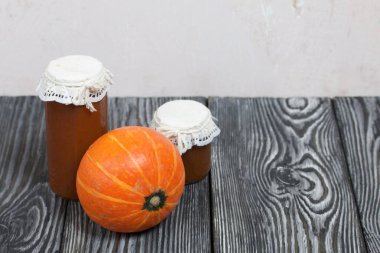 Kavanozda portakal kabağı ve balkabağı reçeli. Çam ağacından yapılmış tahtalarda siyah beyaz boyanmış..