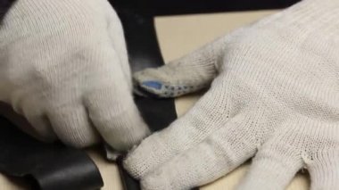 Bir adam bisiklet tüpündeki delinme yerini zımparalıyor. Yapıştırmak için. Yakın çekim..