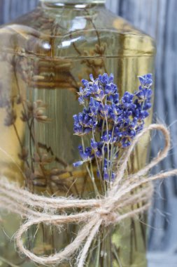 Bir şişe lavantalı votka. Şişeye bir demet lavanta bağlanmış. Siyah beyaz boyanmış çam ağaçlarının arka planında.