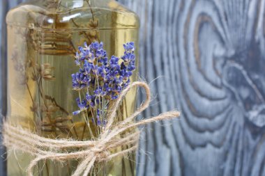 Bir şişe lavantalı votka. Şişeye bir demet lavanta bağlanmış. Siyah beyaz boyanmış çam ağaçlarının arka planında.