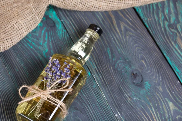 一瓶薰衣草伏特加 一束薰衣草绑在瓶子上 在深绿色的松木板上 — 图库照片