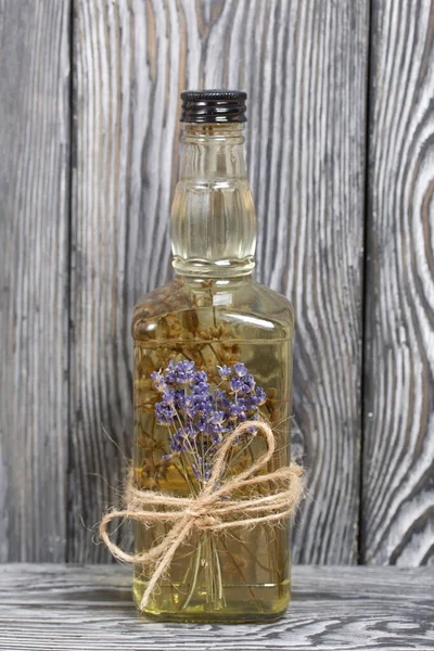 Bir şişe lavantalı votka. Şişeye bir demet lavanta bağlanmış. Siyah beyaz boyanmış çam ağaçlarının arka planında.