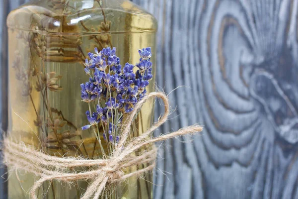 Bir şişe lavantalı votka. Şişeye bir demet lavanta bağlanmış. Siyah beyaz boyanmış çam ağaçlarının arka planında.