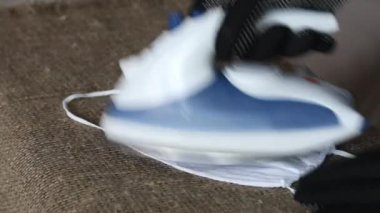 Eldivenli bir adam tekrar kullanılabilir bir tıbbi maske ütülüyor. Coronavirus koruması. Yakın çekim.