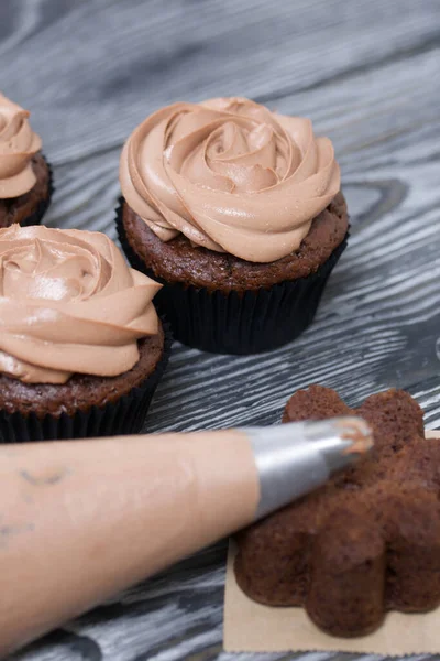 Schoko Cupcakes Mit Frischkäsecreme Daneben Liegt Ein Gebäckbeutel Mit Sahne — Stockfoto