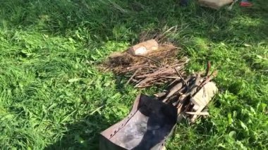 Yeşil bir çayırda metal ızgara. Odunların yanına uzan. Salgın sırasında çayırda piknik.