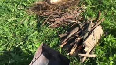 Yeşil bir çayırda metal ızgara. Odunların yanına uzan. Salgın sırasında çayırda piknik