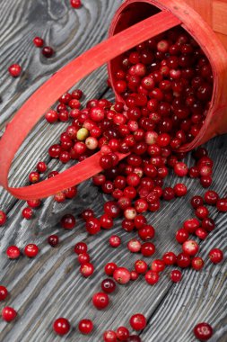 Ters dönmüş bir sepet kızılcık. Böğürtlenler ahşap bir yapı ile kalasların yüzeyine saçılmıştı..