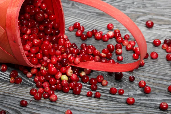 Ters dönmüş bir sepet kızılcık. Böğürtlenler ahşap bir yapı ile kalasların yüzeyine saçılmıştı..