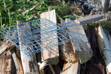 Izgara yakacak odun. Odunun üstünde bir ızgara var. Yakın çekim..
