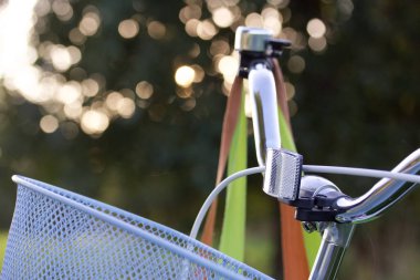 Bir bayan bisikleti parçası. Direksiyon ve sepet. Parkta duruyor. Yakın çekim..