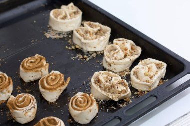 Haşhaş ve tarçınla doldurulmuş hamur parçaları. Fırın tepsisine uzan. Çörek pişiriyorum..