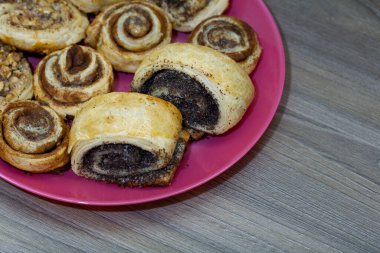 Haşhaş, tarçın ve cevizle doldurulmuş fırında çörekler. Tabağa uzan..